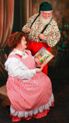Mrs. Claus reads a story while Santa looks on.